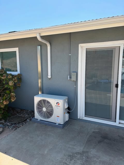 Heat pump outdoor unit on a pad next to a home